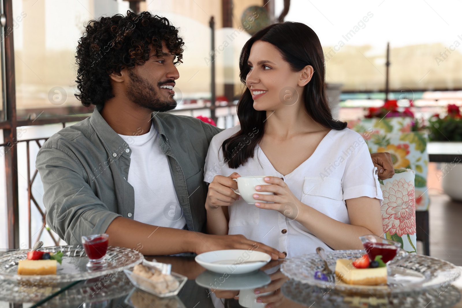 Photo of International dating. Happy couple spending time together in restaurant