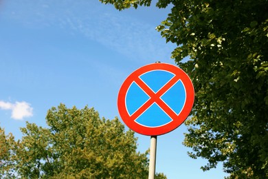 Photo of Road sign No Stopping against blue sky. Space for text