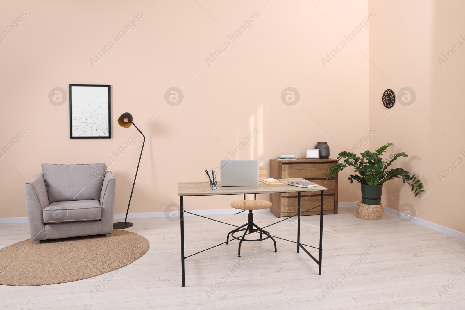 Photo of Stylish workplace with desk, chair and potted plant in room. Home office