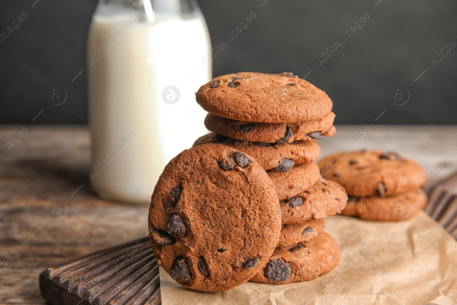 Photo of Stack of tasty chocolate chip cookies on wooden board