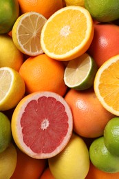 Different fresh citrus fruits as background, top view