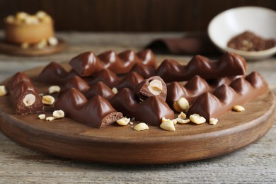 Tasty chocolate bars with nuts on wooden table