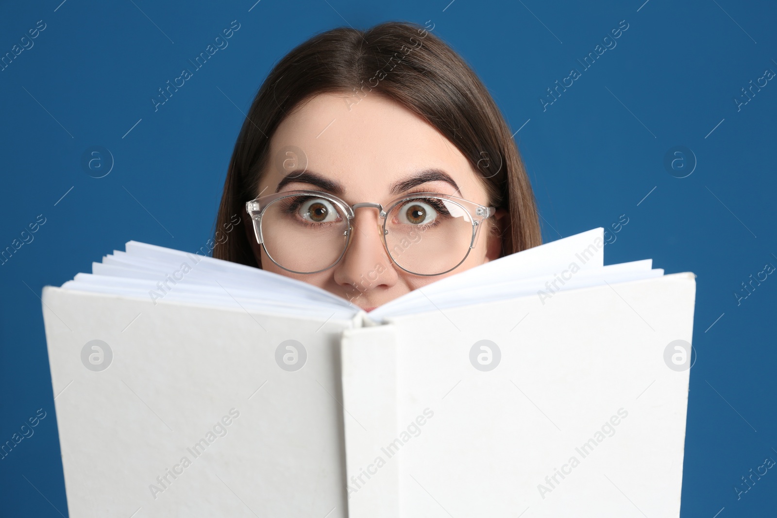 Photo of Young woman with book on blue background