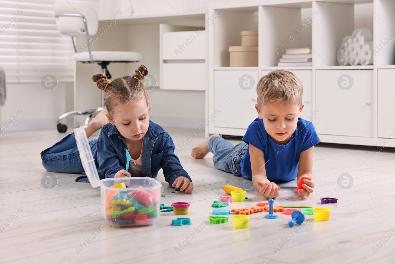 Photo of Cute little children playing on warm floor at home. Heating system