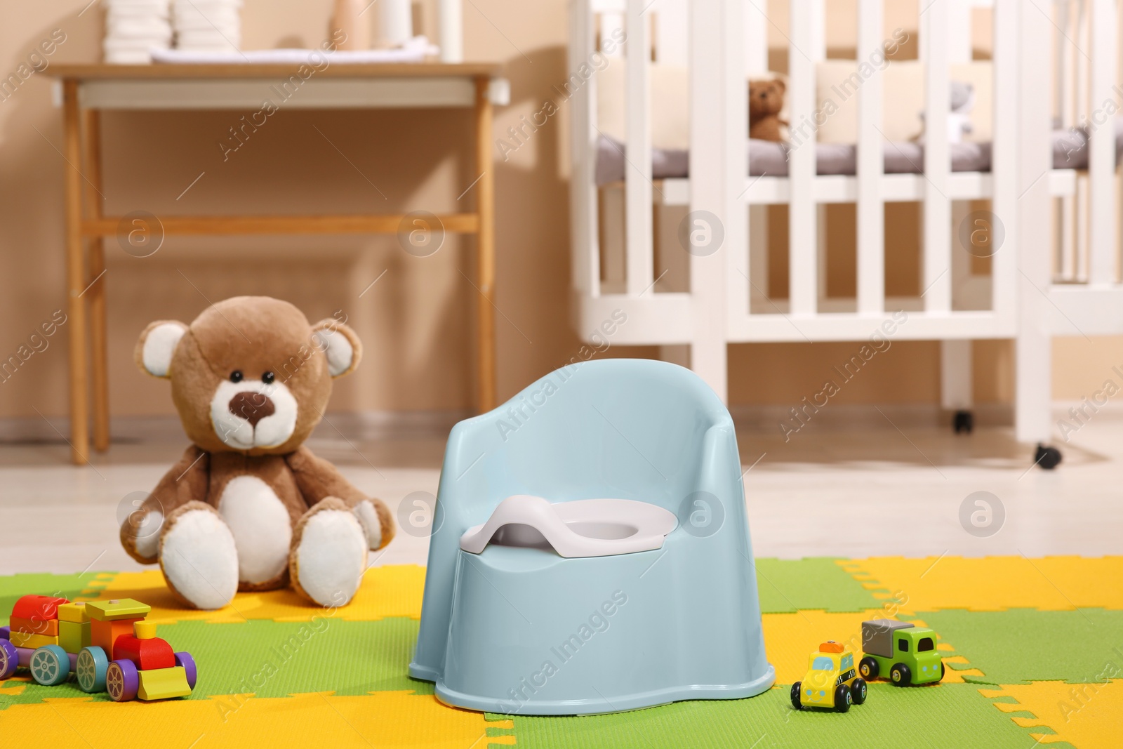 Photo of Light blue baby potty and toys in room. Toilet training