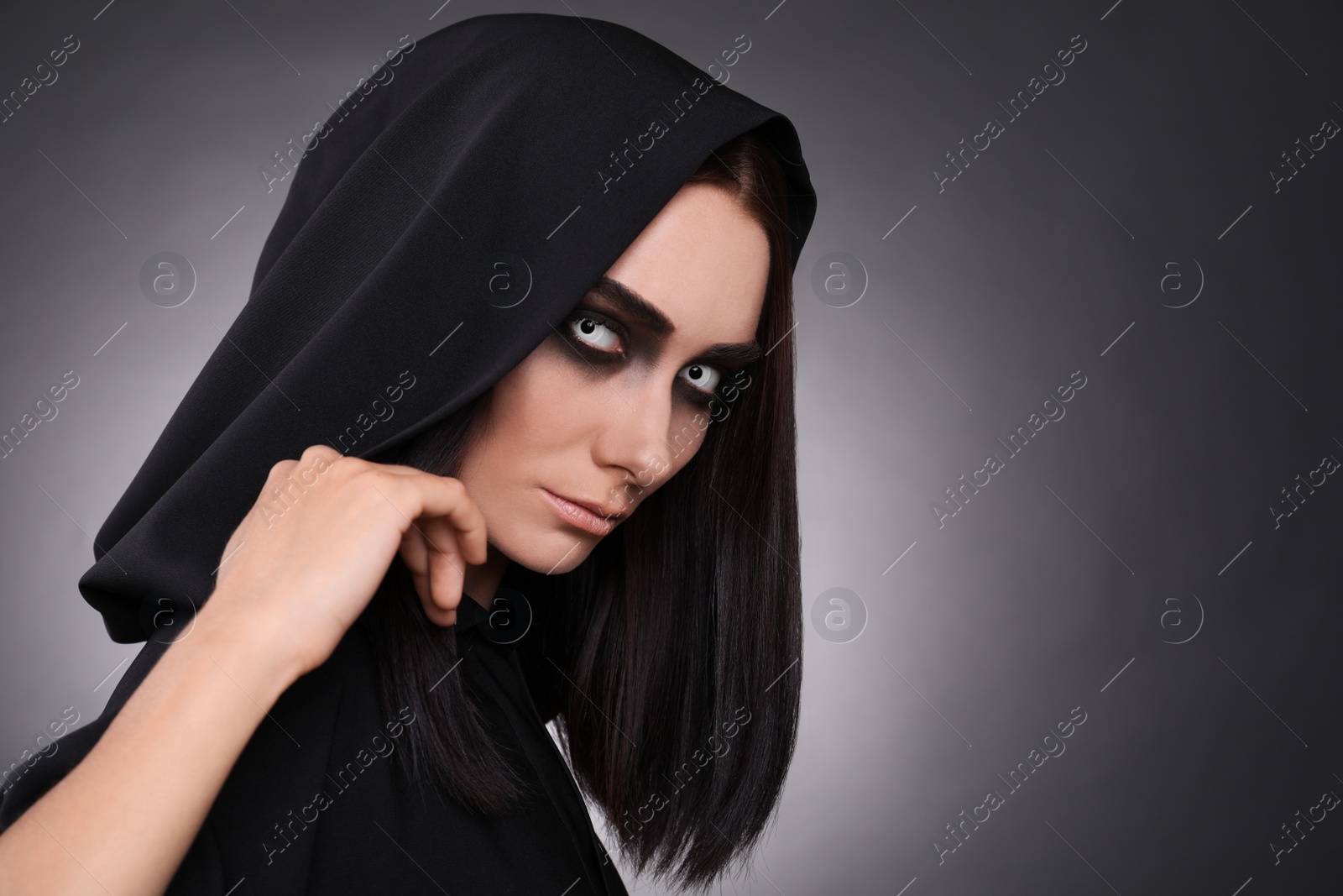 Photo of Mysterious witch with spooky eyes on dark background