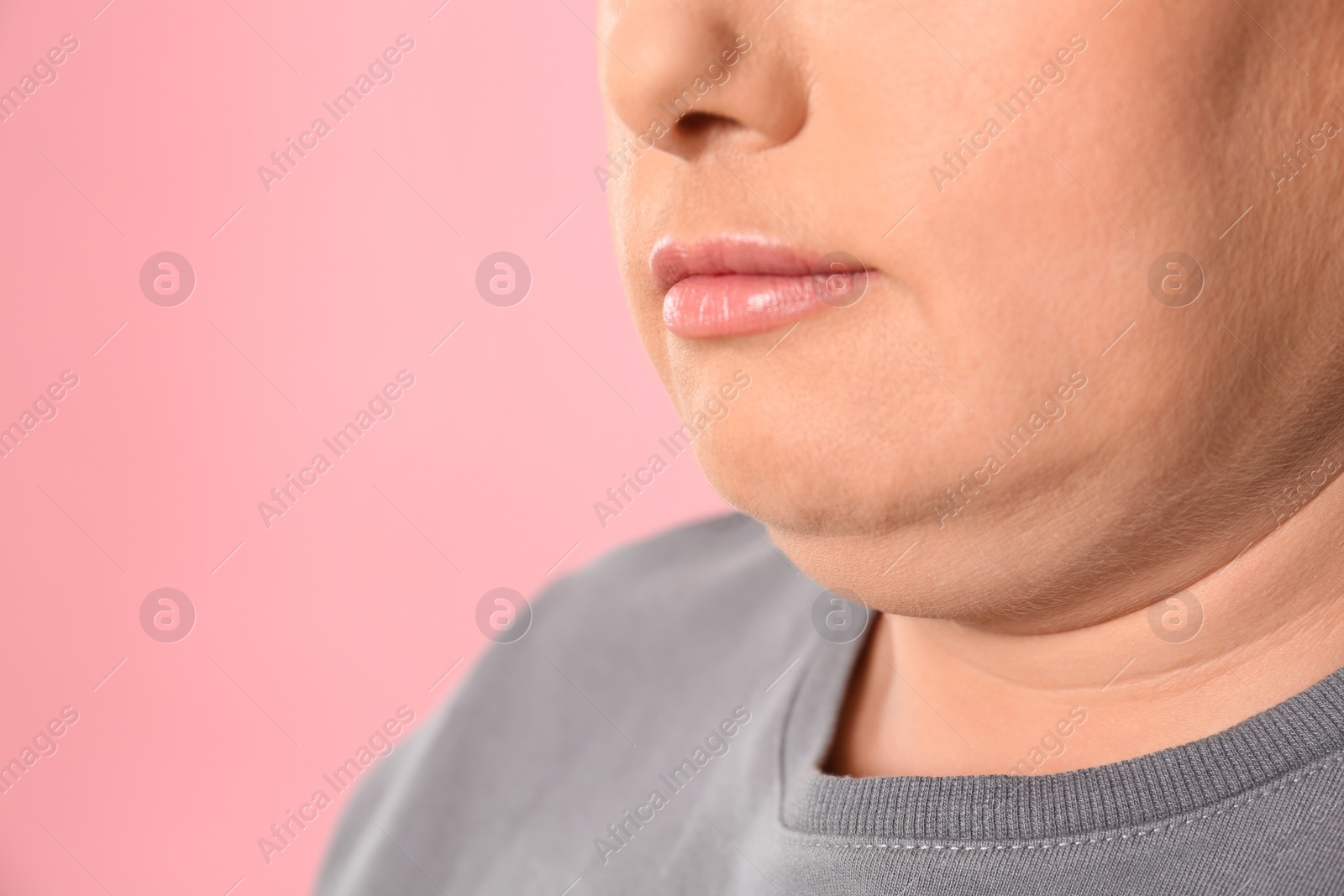 Photo of Woman with double chin on pink background, closeup. Space for text