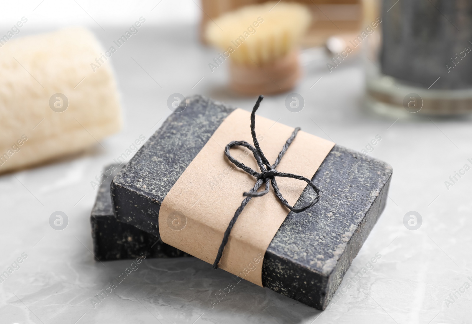 Photo of Natural tar soap on light grey table, closeup