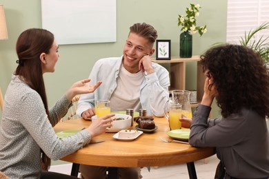 Happy friends having vegetarian meal in cafe