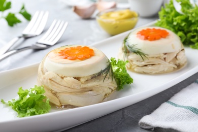 Photo of Delicious chicken aspic with eggs and vegetables on plate, closeup