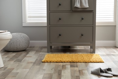 Mat near chest of drawers in bathroom