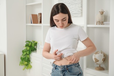 Photo of Diabetes. Woman making insulin injection into her belly at home