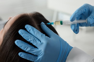 Photo of Trichologist giving injection to patient in clinic, closeup