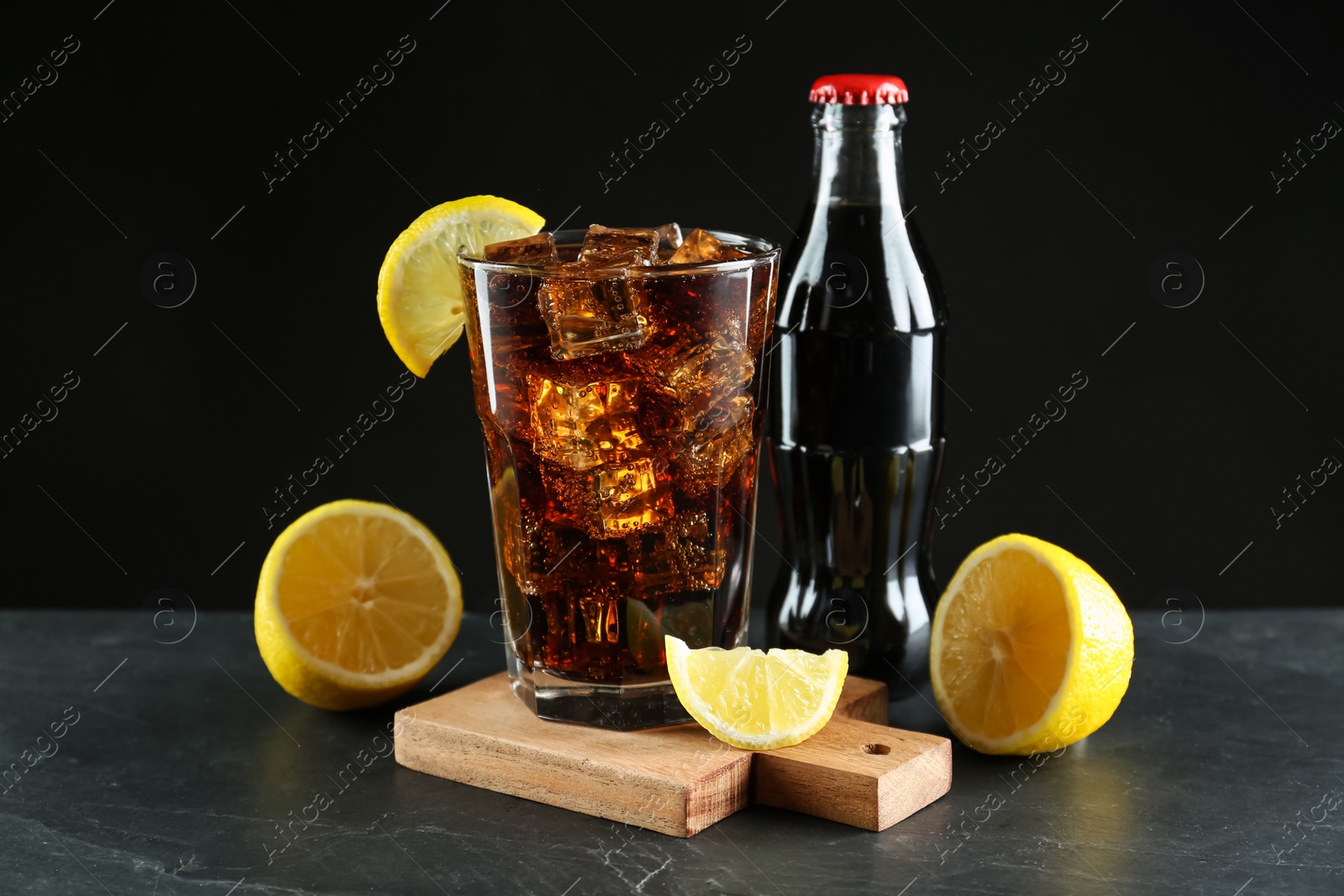 Photo of Bottle and glass of refreshing soda water on black table