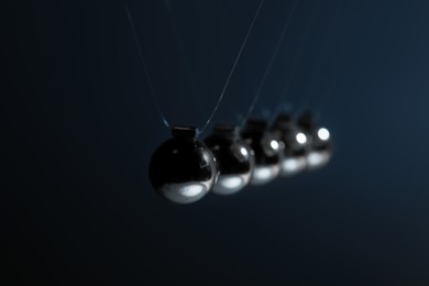 Newton's cradle on black background, closeup. Physics law of energy conservation
