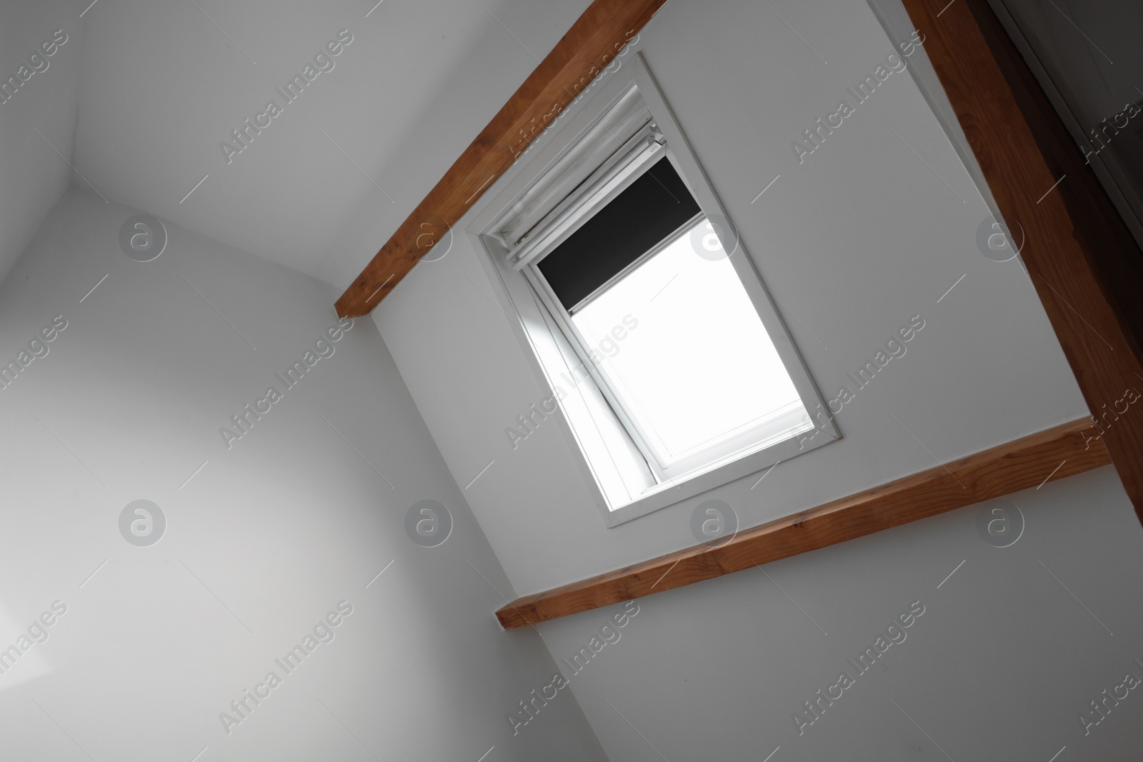 Photo of Roof window on slanted ceiling indoors, low angle view