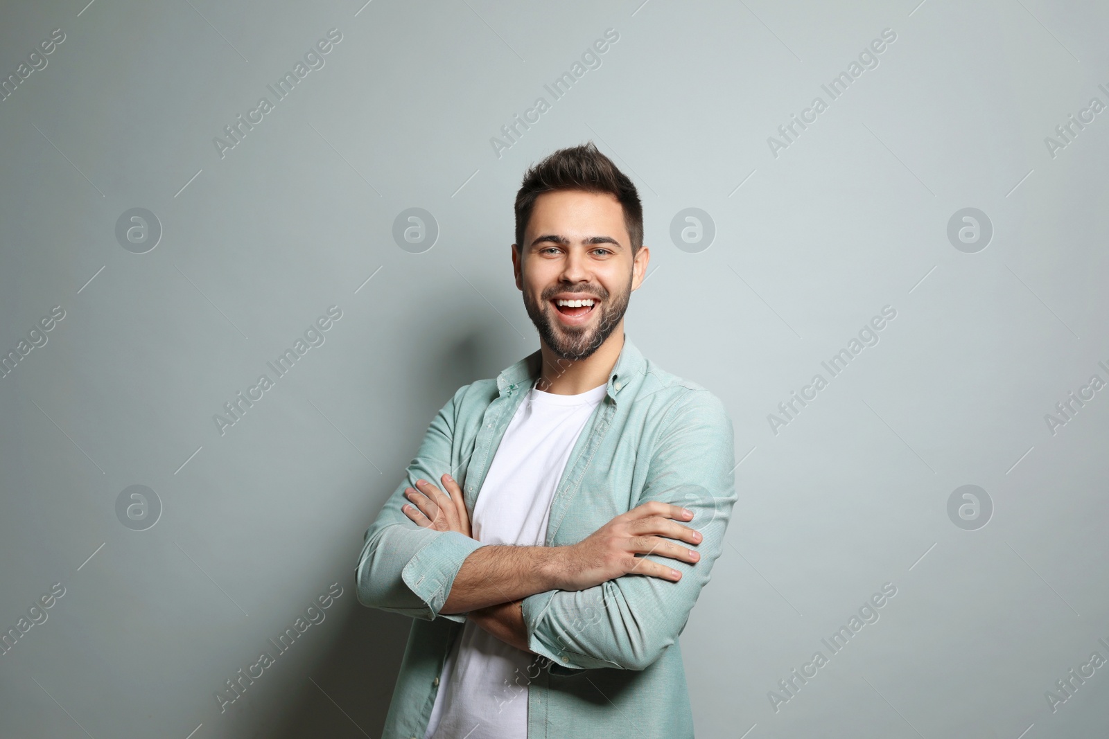 Photo of Young man laughing on light grey background. Funny joke