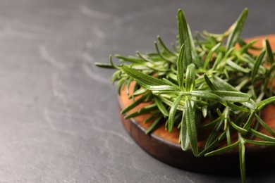 Photo of Fresh green rosemary on grey table, closeup. Space for text