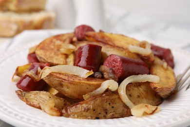 Photo of Delicious baked potato with thin dry smoked sausages and onion on table, closeup