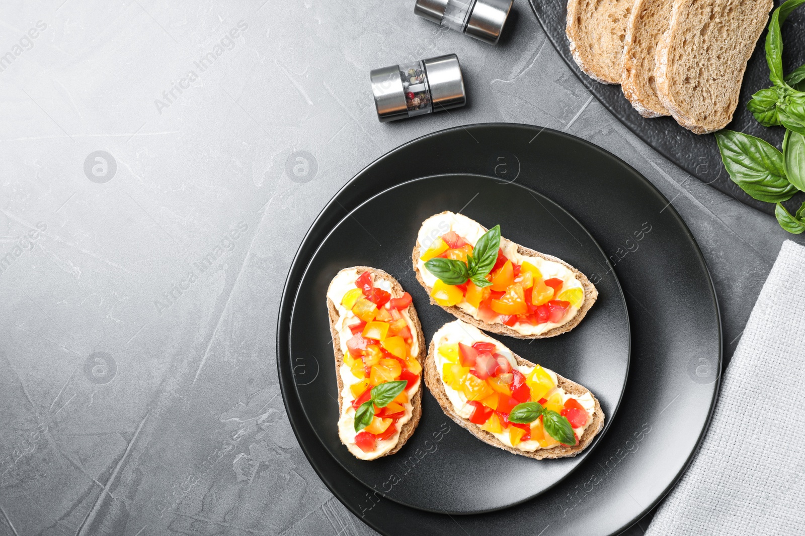 Photo of Tasty fresh tomato bruschettas on grey table, flat lay. Space for text