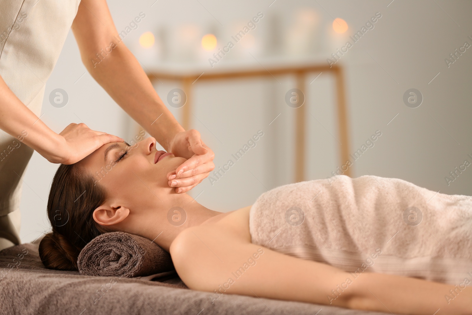 Photo of Beautiful young woman enjoying massage in spa salon