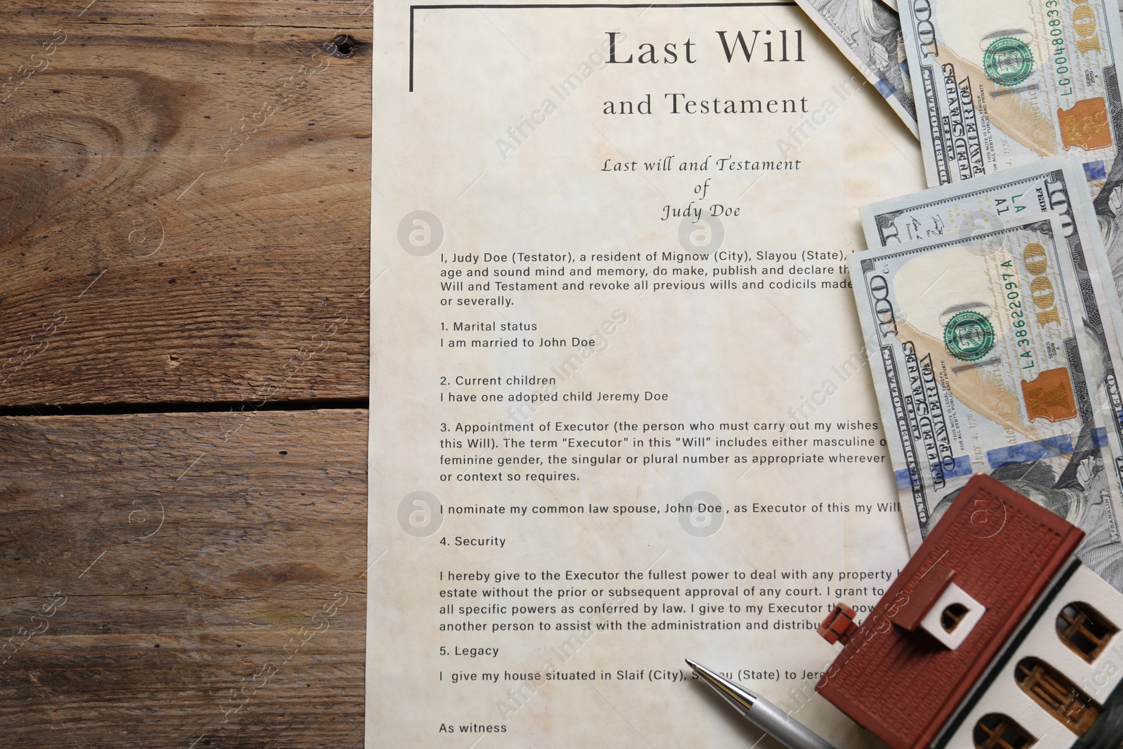 Photo of Last Will and Testament, dollar bills, house model and pen on wooden table, flat lay. Space for text