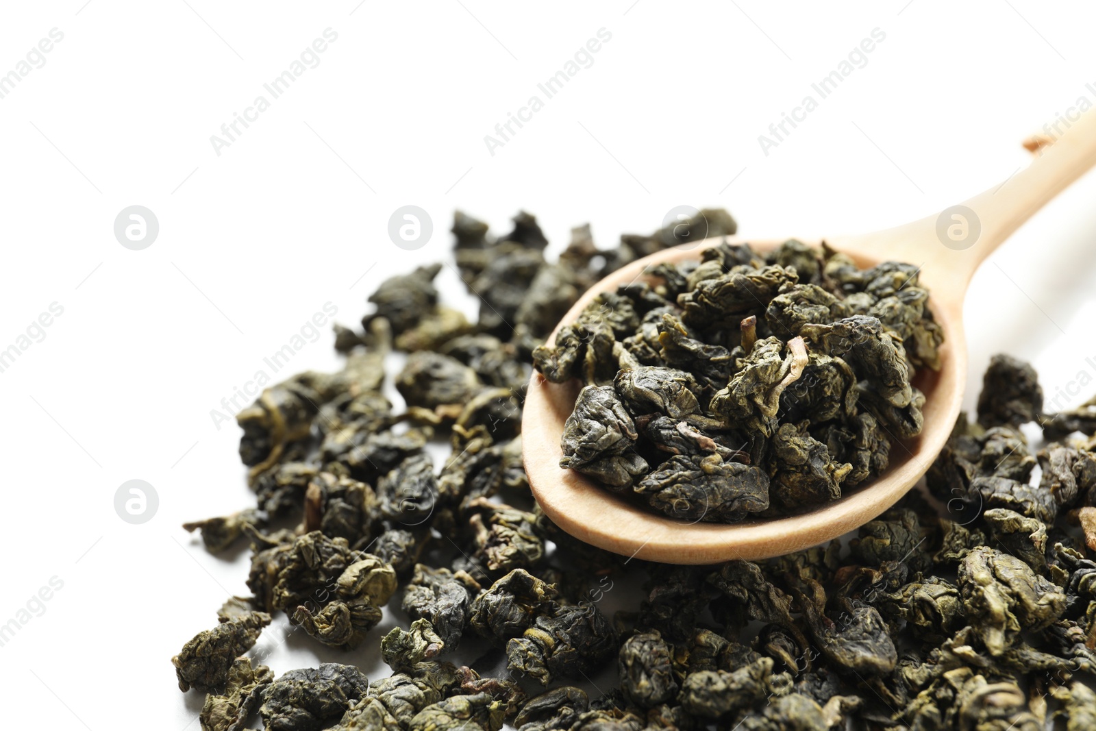 Photo of Tie Guan Yin oolong tea leaves and spoon on white background, closeup