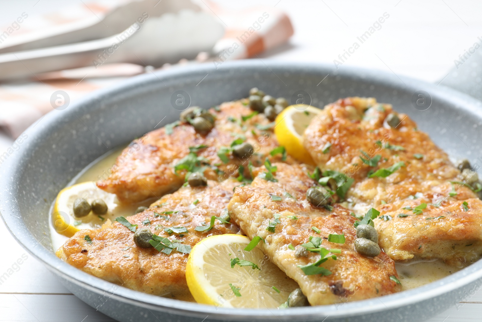 Photo of Delicious chicken piccata in pan on table, closeup