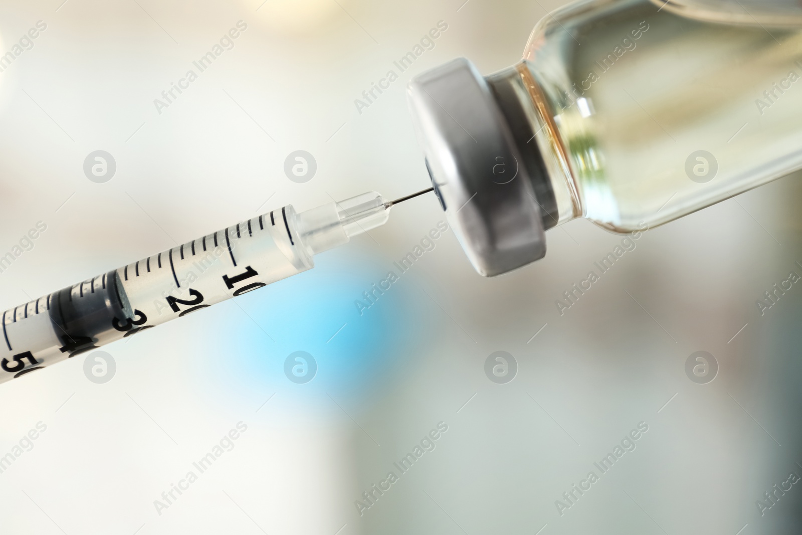 Photo of Filling syringe with vaccine on blurred background, closeup