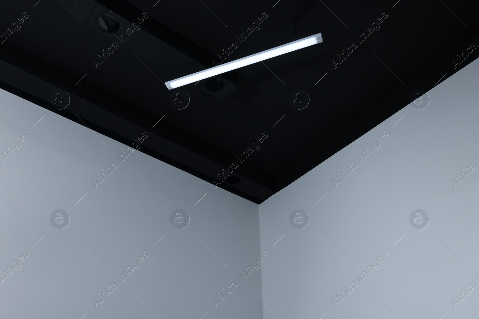 Photo of Room corner and black ceiling with modern light