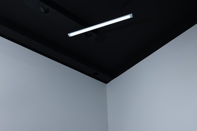 Room corner and black ceiling with modern light