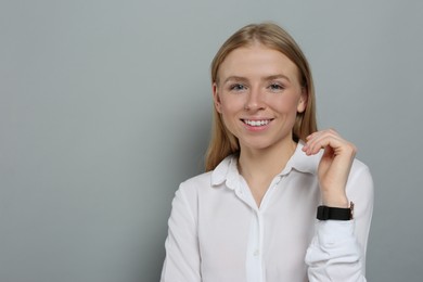 Photo of Portrait of beautiful young woman in white shirt on grey background. Space for text