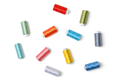 Photo of Color sewing threads on white background, top view