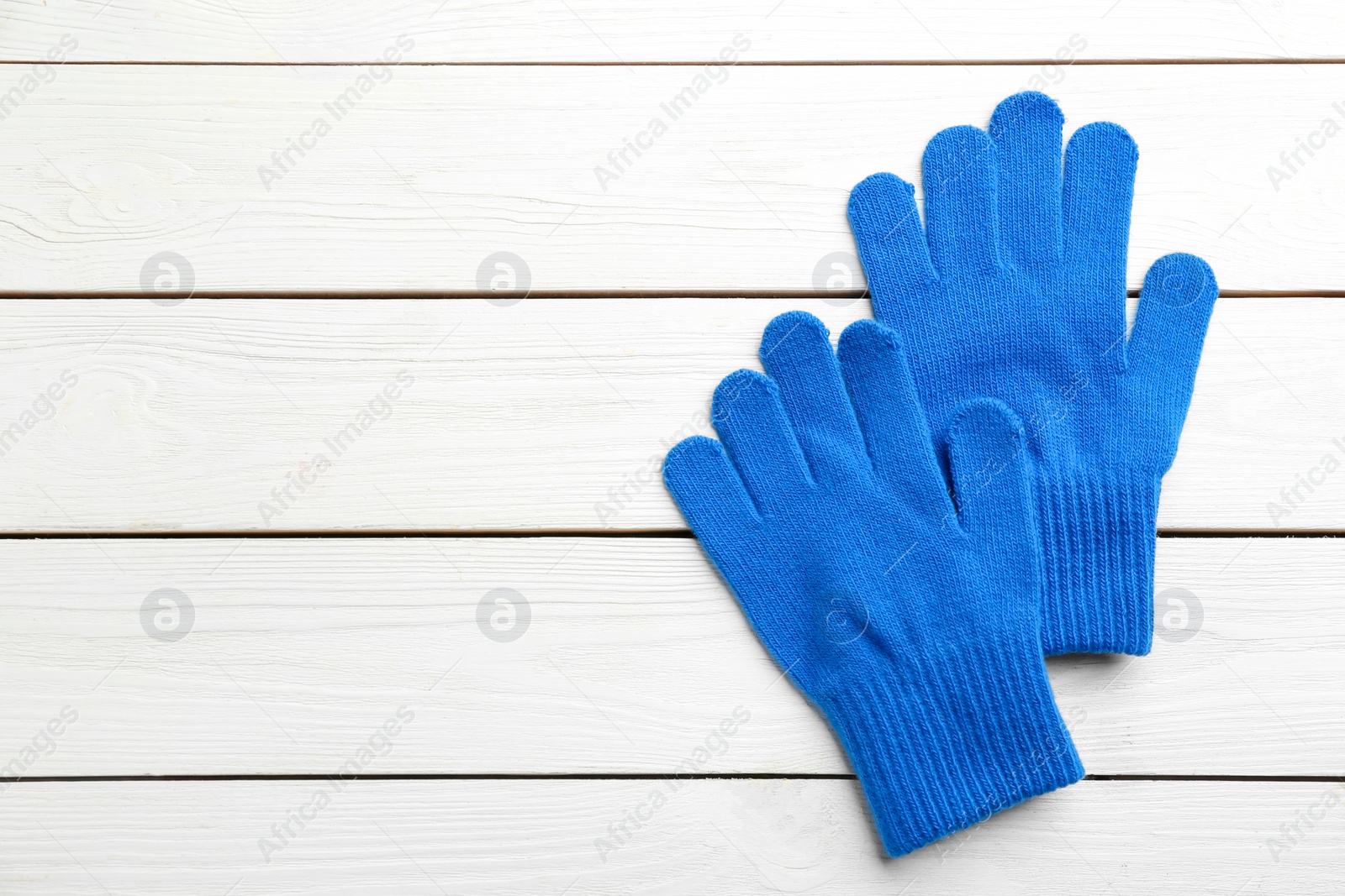 Photo of Stylish blue gloves on white wooden background, flat lay. Space for text