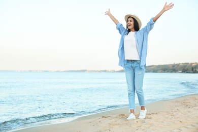 Photo of Beautiful young woman in casual outfit on beach