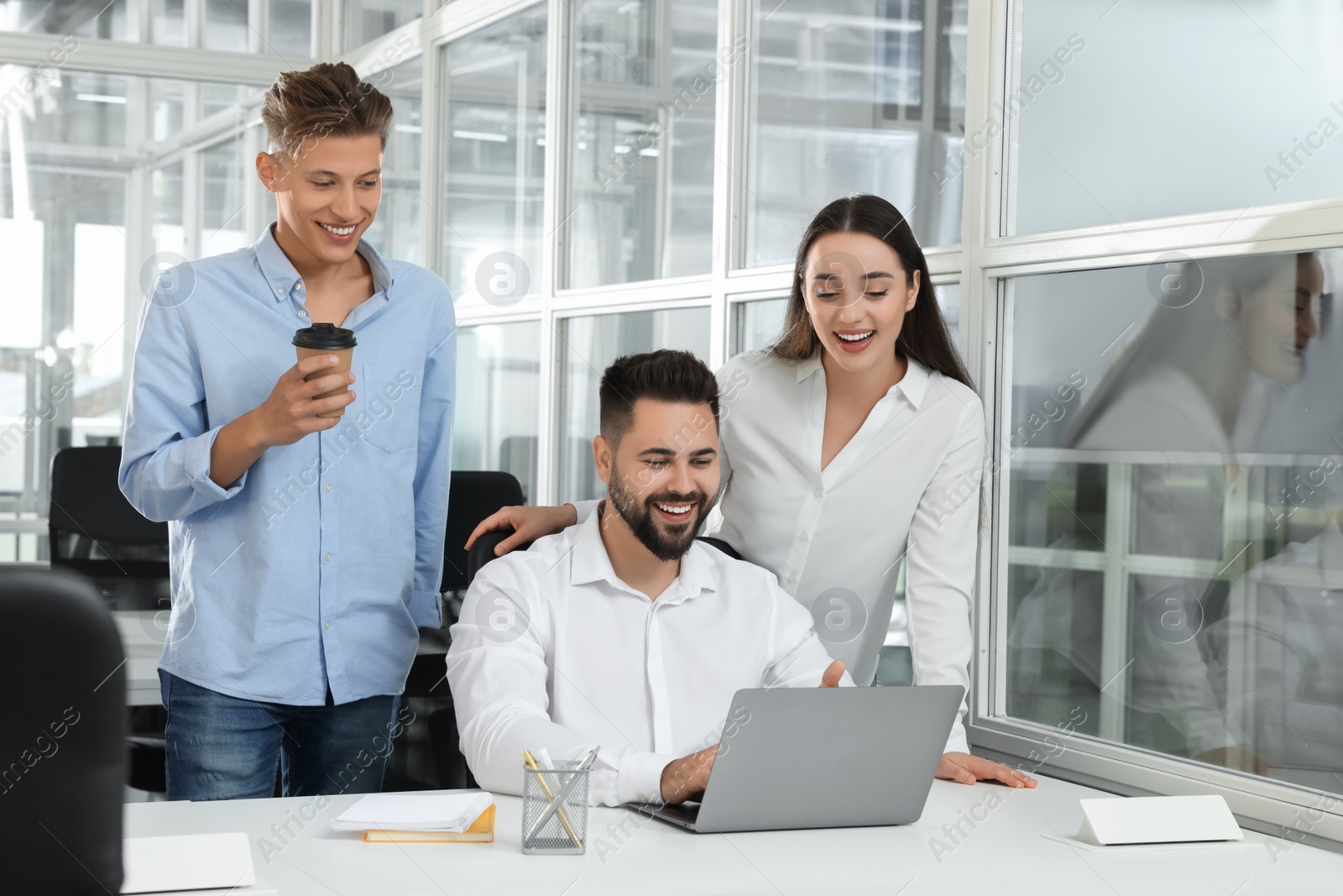 Photo of Colleagues working together in open plan office