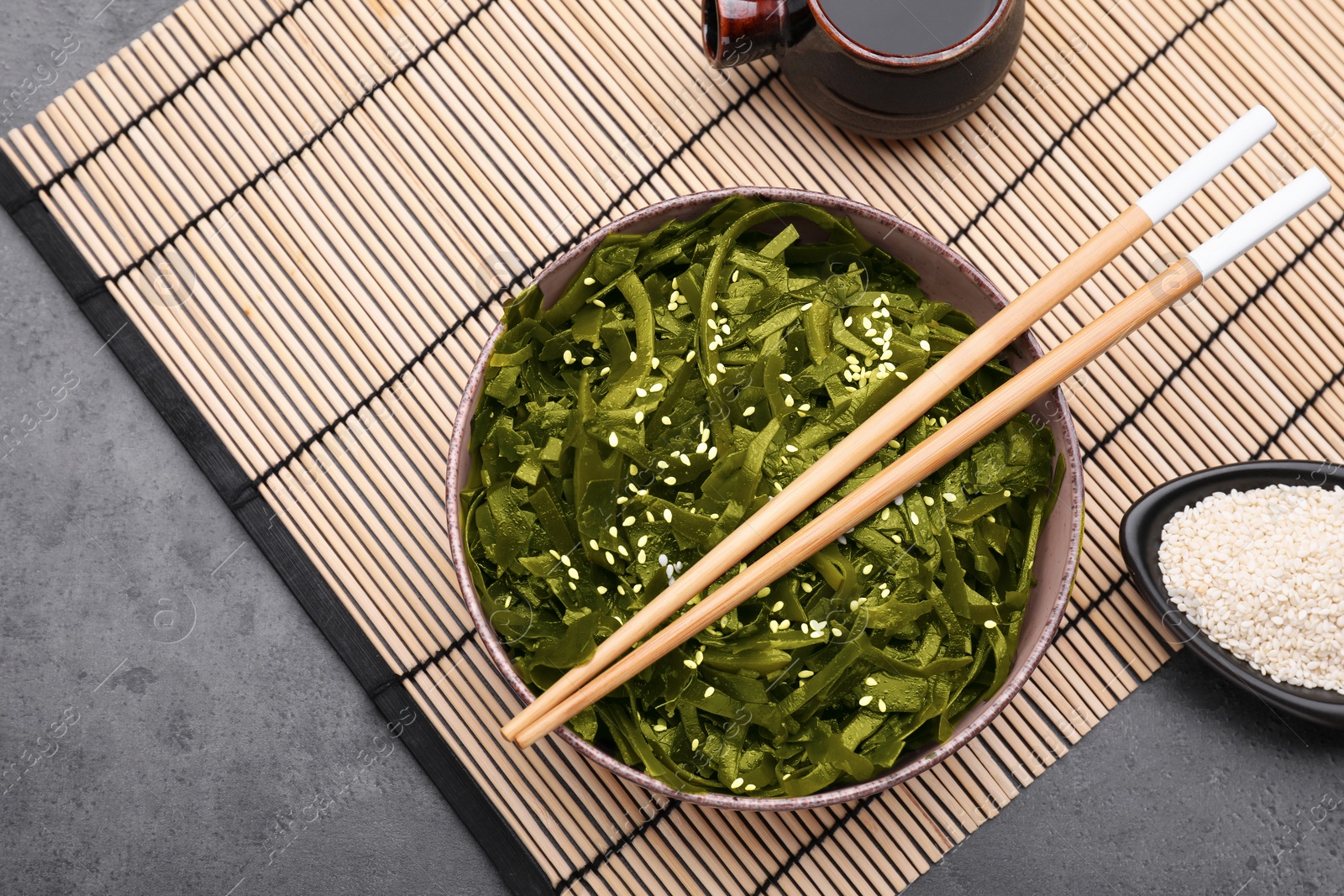 Photo of Fresh laminaria (kelp) seaweed served on black table, flat lay