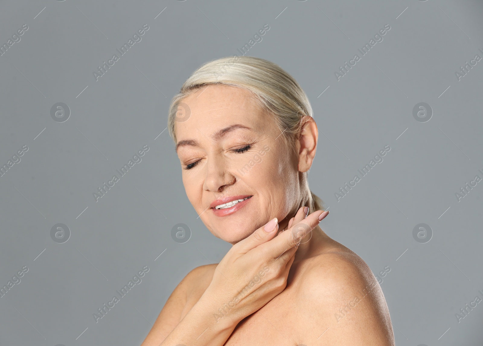 Photo of Portrait of beautiful mature woman on grey background