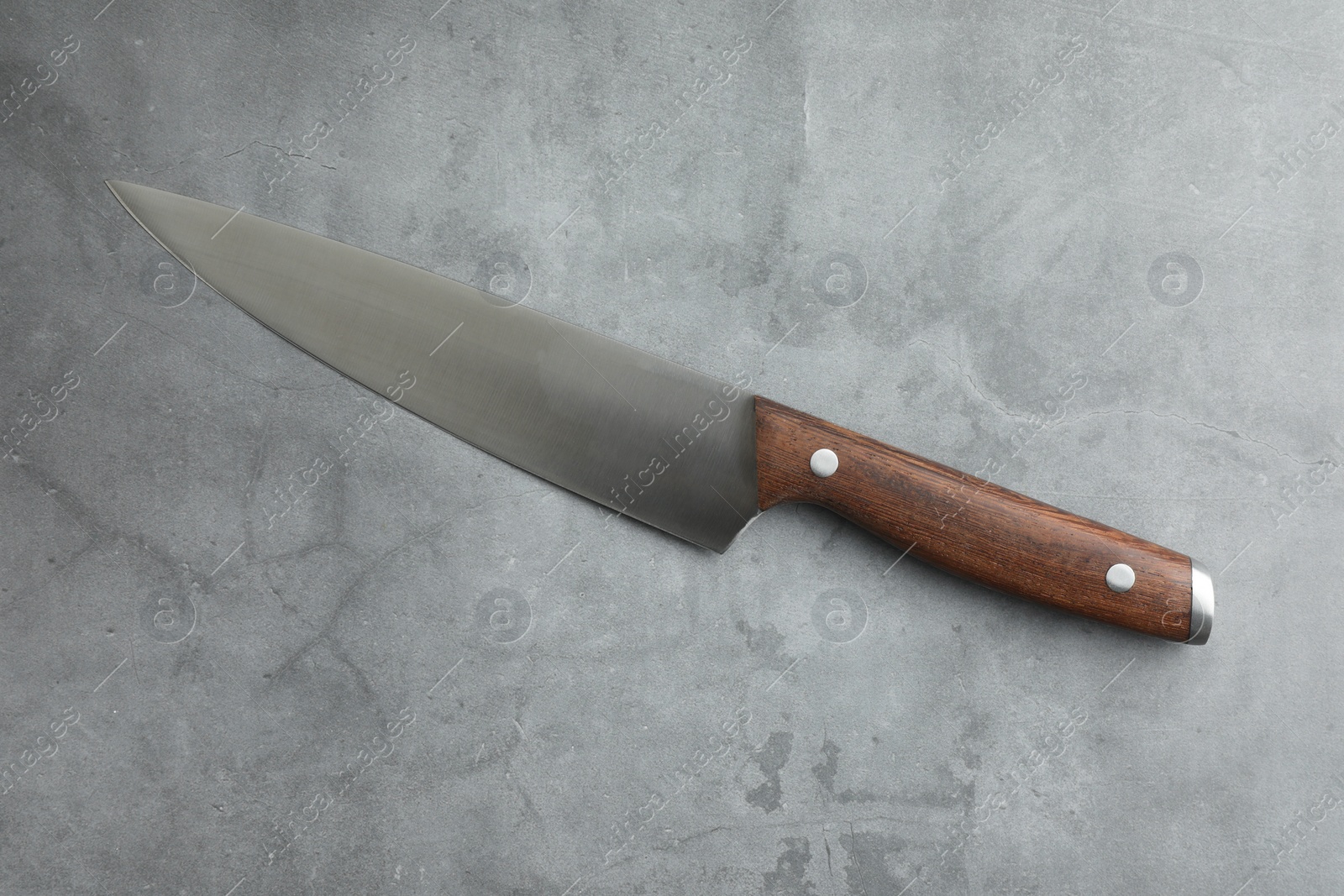 Photo of One knife on grey textured table, top view