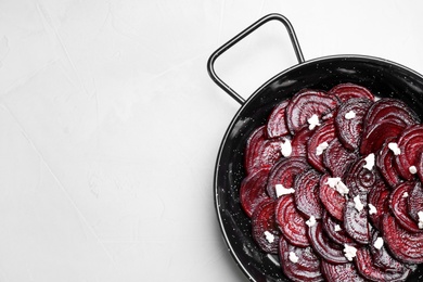 Photo of Roasted beetroot slices with feta cheese in wok pan on light grey table, top view. Space for text