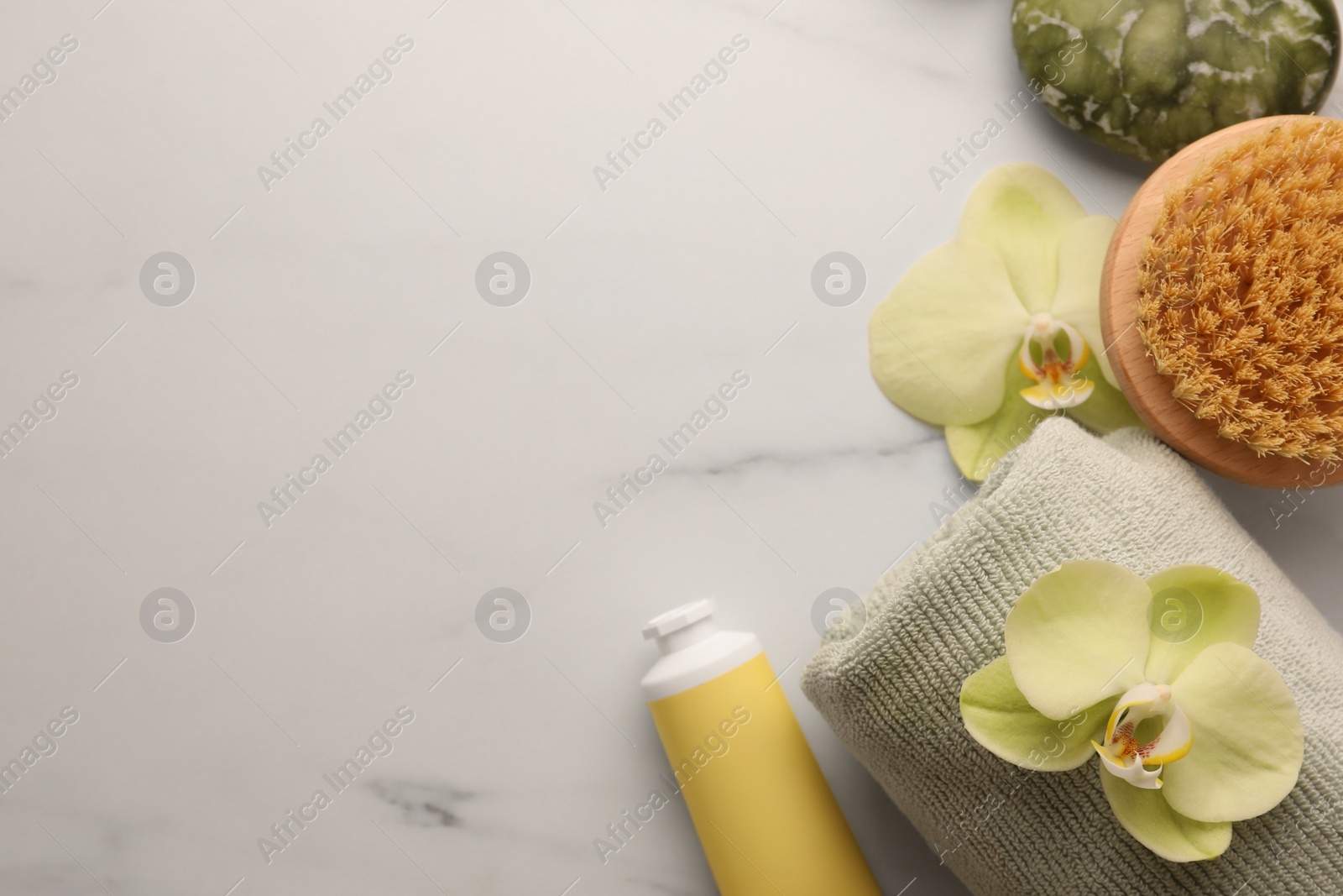 Photo of Flat lay composition with spa products and beautiful flowers on white marble table. Space for text