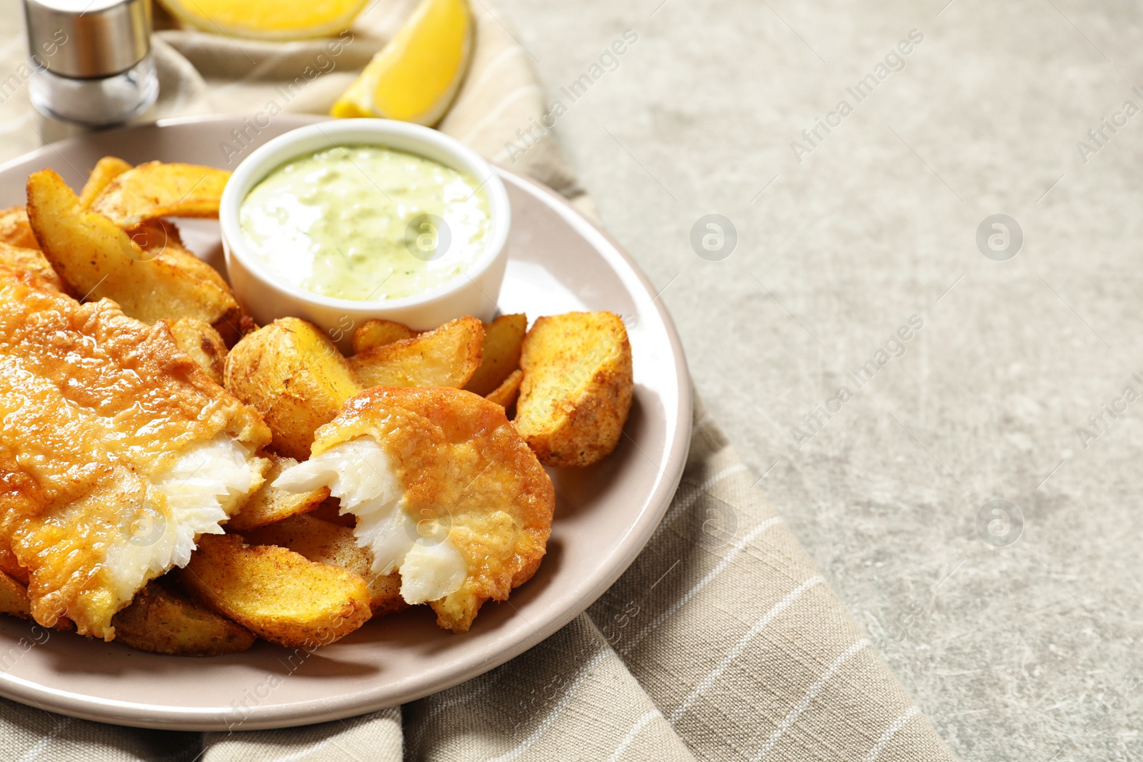 Photo of Plate with British Traditional Fish and potato chips on grey background. Space for text