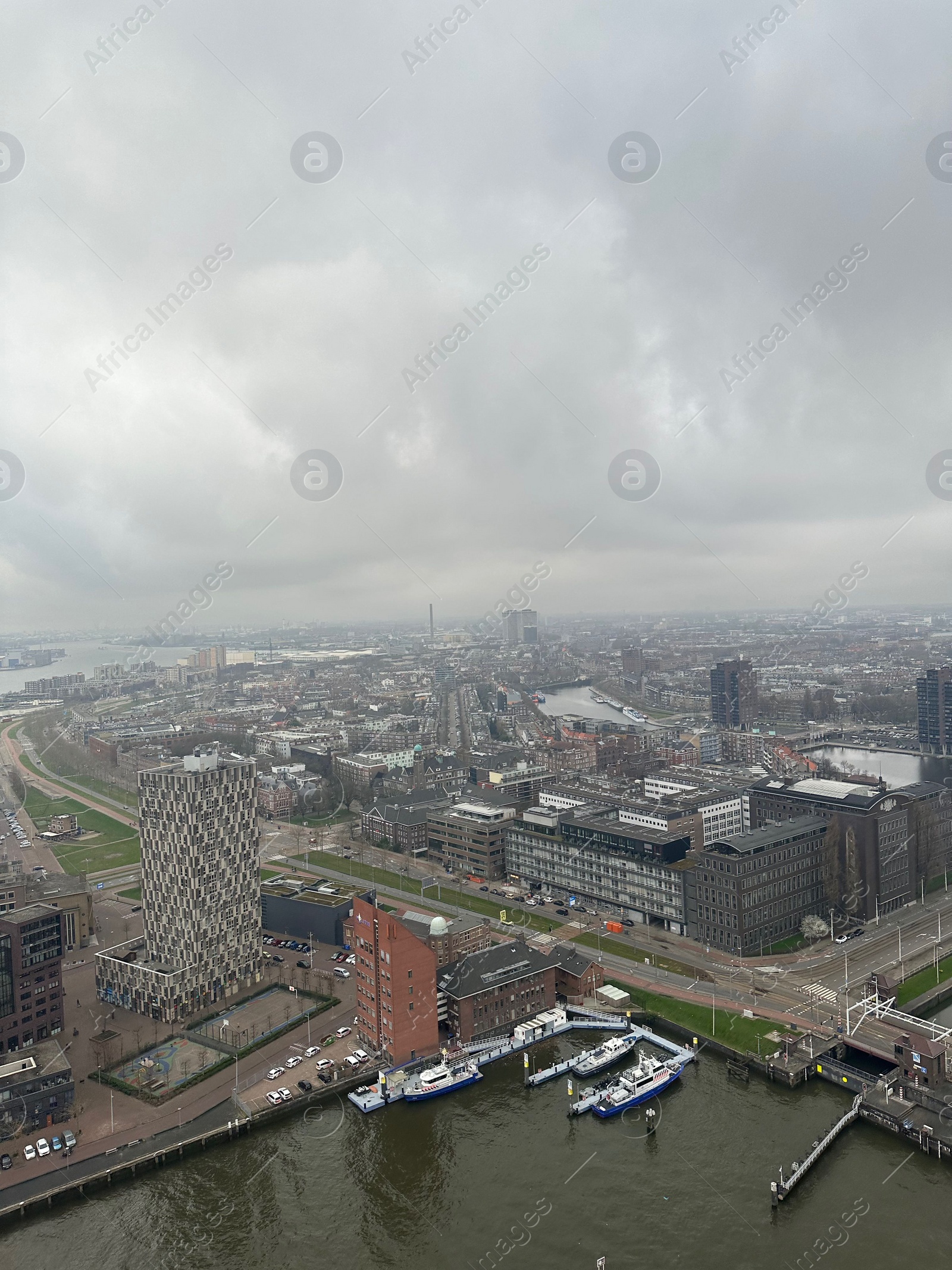 Photo of Picturesque view of city with modern buildings and harbor on cloudy day