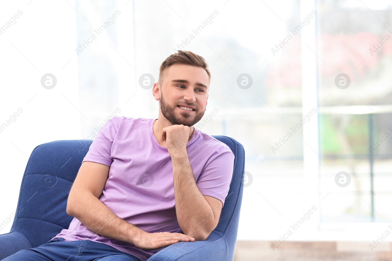 Photo of Portrait of confident young man in armchair