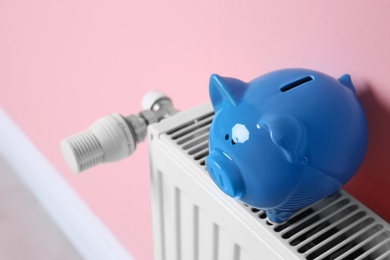 Heating radiator with piggy bank near color wall