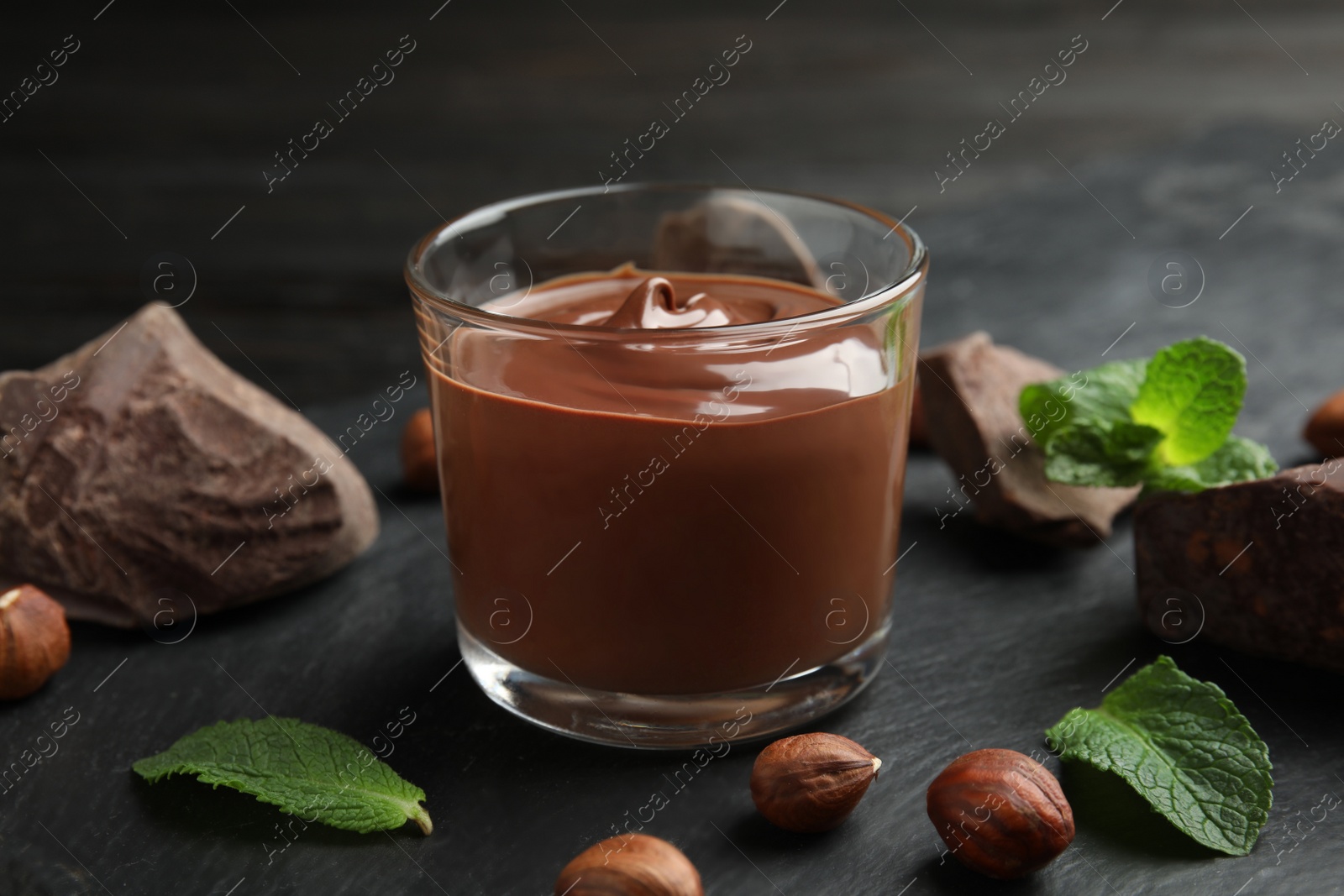 Photo of Composition with sweet chocolate mousse in glass on table