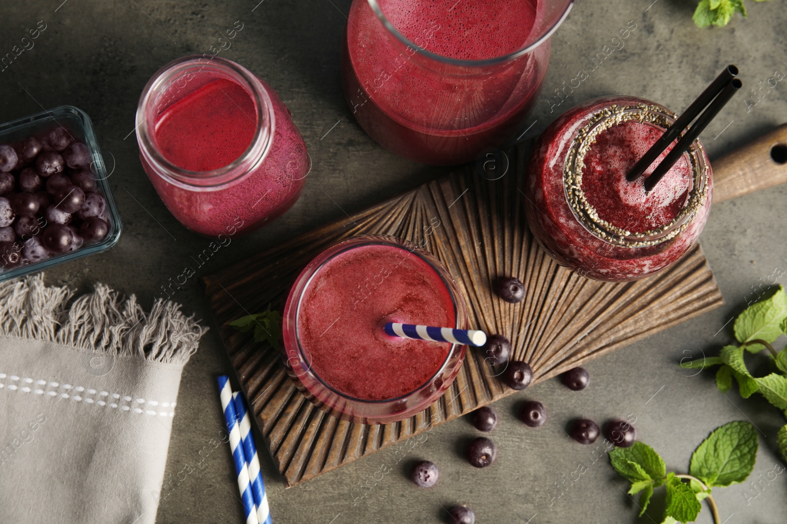 Photo of Flat lay composition with delicious acai juice on dark table