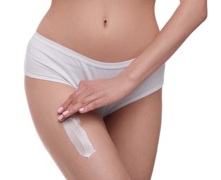 Photo of Woman with smear of body cream on her leg against white background, closeup