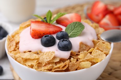 Photo of Delicious crispy cornflakes, yogurt and fresh berries in bowl, closeup. Healthy breakfast