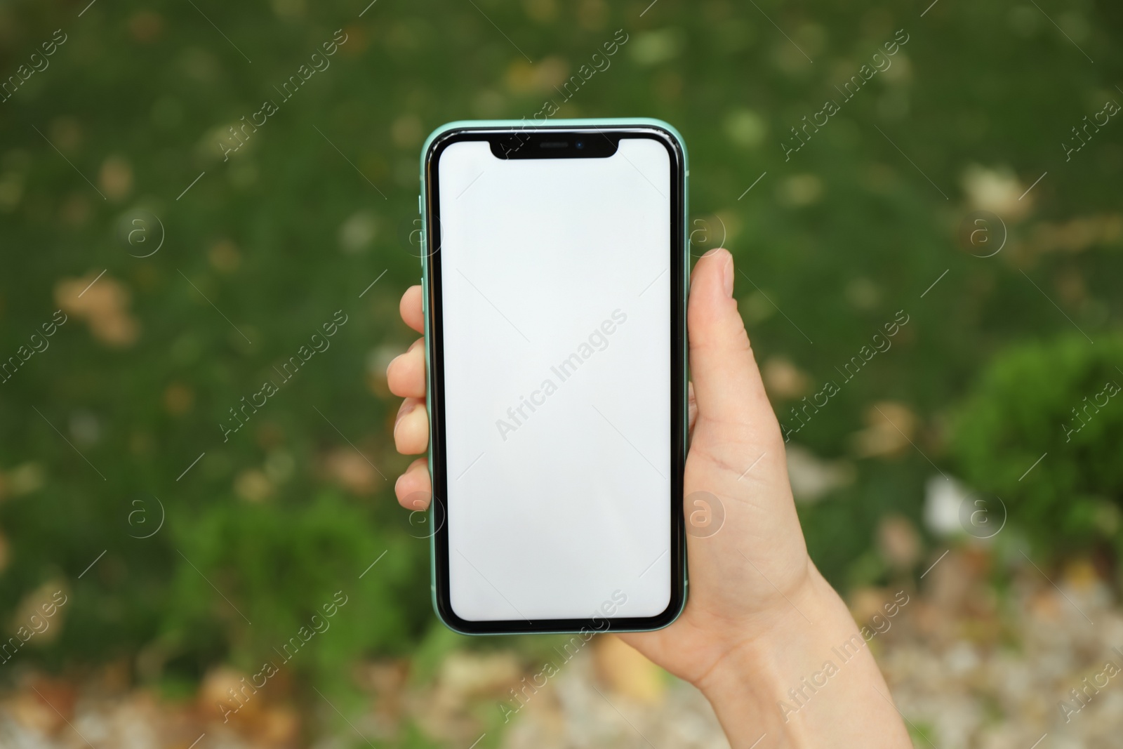 Photo of MYKOLAIV, UKRAINE - JULY 8, 2020: Woman holding Iphone 11 Pro Max with blank screen outdoors, closeup